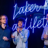 Boy talks into microphone while holding champagne glass